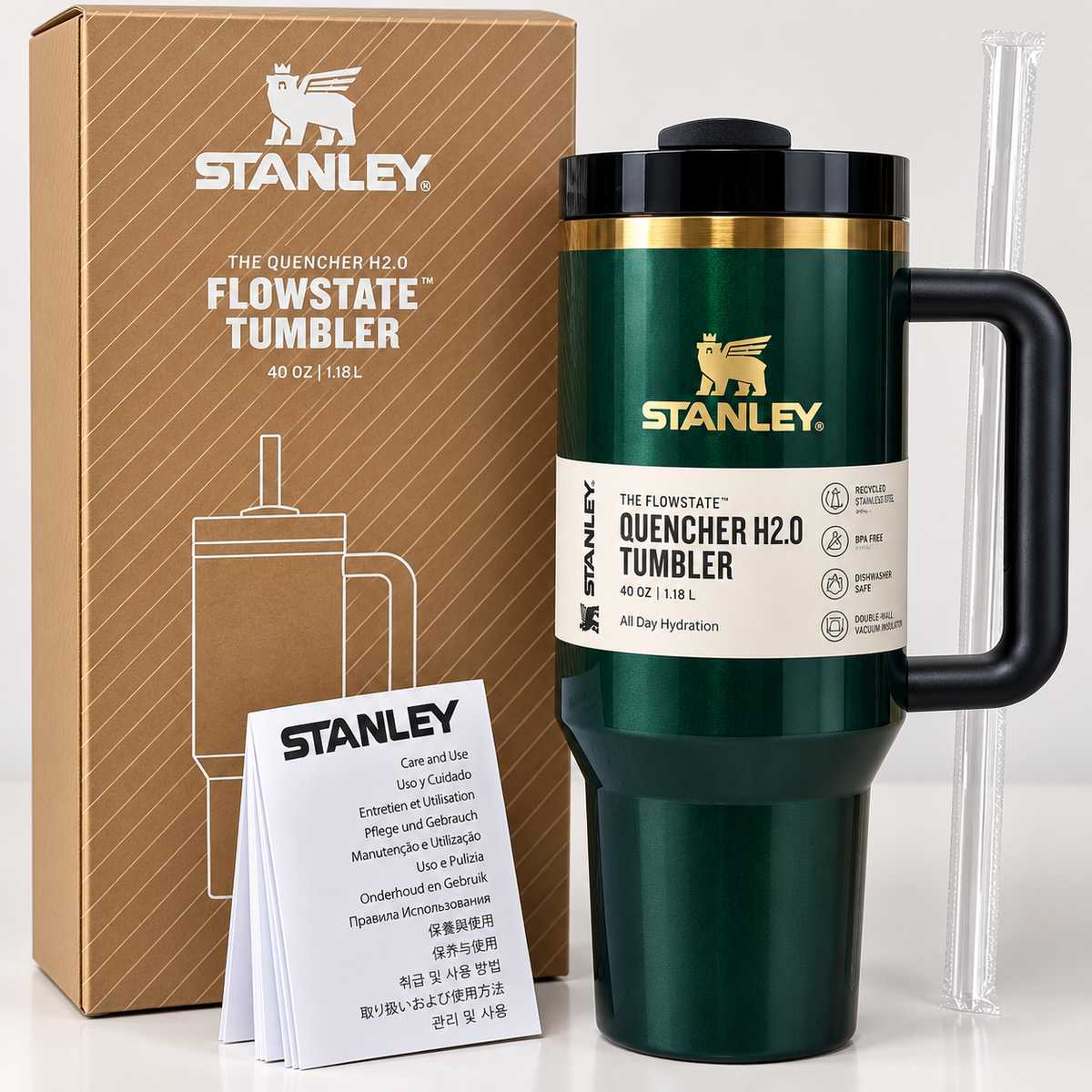 Stanley FlowState Quercher H2.0 insulated travel tumbler in dark green with a black handle and lid, shown with its brown branded box, small instruction cards, and a clear straw on a light gray background.